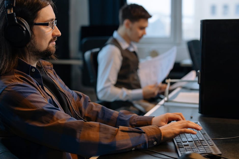 Two office workers focused on tasks at their desks in a modern workspace
